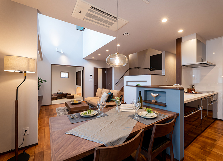 キッチンとダイニングテーブルを横並びにして家事動線もスムーズ。キッチンに立ちながら、1階全体を見渡せます。<br />
リビングは大きな吹き抜けが解放感あふれ、あたたかな光に包まれる安らぎの空間です。